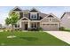 Charming two-story home showcasing a well-manicured lawn and a welcoming covered front porch at 13204 Caterwood Cir, Fishers, IN 46037
