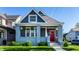 Charming home with a welcoming red door, light blue brick and siding, a well manicured lawn, and an inviting porch at 1330 Marlowe Ave, Indianapolis, IN 46202