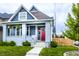 Charming home with a front porch featuring hanging plants and a lush green lawn at 1330 Marlowe Ave, Indianapolis, IN 46202