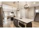 Open concept kitchen featuring a dark island with seating and quartz countertops connecting to dining and living spaces at 1330 Marlowe Ave, Indianapolis, IN 46202