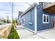 View of home's blue vinyl siding, wooden fence, and new concrete patio with steps at 1330 Marlowe Ave, Indianapolis, IN 46202