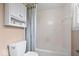 Bathroom featuring a tub with a shower curtain, a toilet, a cabinet, and neutral walls at 13363 Lantern Rd, Fishers, IN 46038