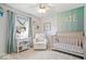 Comfortable Bedroom with a soft color scheme, ceiling fan, crib, glider and adorable decor at 13363 Lantern Rd, Fishers, IN 46038