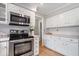 Well-equipped kitchen with stainless steel appliances, white cabinets, and tiled backsplash at 13363 Lantern Rd, Fishers, IN 46038