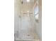 Modern glass shower enclosure with neutral tiling, a rainfall shower head and built-in shower caddy niches at 13363 Lantern Rd, Fishers, IN 46038