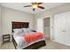 Bedroom with a dark wood bedframe, ceiling fan, side table, and closet with white bi-fold doors at 1404 Rosebank Dr, Westfield, IN 46074