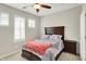 Bright bedroom featuring a dark wood bedframe, neutral walls, two windows, and a ceiling fan at 1404 Rosebank Dr, Westfield, IN 46074