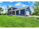Side view of blue two-story home featuring a green lawn, backyard patio, and attached garage at 1404 Rosebank Dr, Westfield, IN 46074