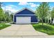 Garage exterior with a driveway and manicured lawn set against a blue house at 1404 Rosebank Dr, Westfield, IN 46074