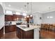 Well-lit kitchen featuring an island, dark wood cabinetry, stainless steel appliances, and hardwood floors at 1404 Rosebank Dr, Westfield, IN 46074