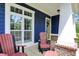 Inviting porch with a seating area, white columns, brick accents, and a bright yellow front door at 1404 Rosebank Dr, Westfield, IN 46074