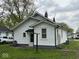 View of the rear of the home showing a small back entry and lush lawn at 1405 S Ribble Ave, Muncie, IN 47302