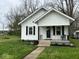 Charming home with a welcoming front porch, black shutters, and a well-manicured lawn at 1405 S Ribble Ave, Muncie, IN 47302