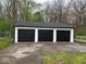 Detached three-car garage with three black garage doors and white trim at 1405 S Ribble Ave, Muncie, IN 47302
