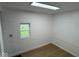 Clean finished room with wood-look floors, brick-patterned paneled walls, and a single window for natural light at 1405 S Ribble Ave, Muncie, IN 47302