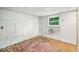 A bedroom features hardwood floors, white walls, a window with natural light, and wainscoting at 1529 E Gimber St, Indianapolis, IN 46203