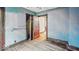 A simple bedroom features hardwood floors, light blue walls, and a dark-trimmed open door at 1529 E Gimber St, Indianapolis, IN 46203