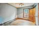 A bedroom features original hardwood floors, light walls, and a window that is bringing in natural light at 1529 E Gimber St, Indianapolis, IN 46203