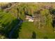 Aerial view of estate, complete with winding drive and in-ground pool surrounded by lush landscaping and mature trees at 15617 Westfield Blvd, Carmel, IN 46033
