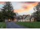 Charming two-story home with three-car garage and lush green lawn under a vibrant sunset sky at 15617 Westfield Blvd, Carmel, IN 46033