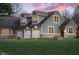 Beautiful home featuring a three-car garage, well-manicured lawn, and exterior stone accents at 15617 Westfield Blvd, Carmel, IN 46033