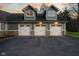 Close-up view of the home's three-car garage with stone accents and dormer windows at 15617 Westfield Blvd, Carmel, IN 46033