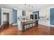 Kitchen with an island and seating, white cabinets, stainless steel appliances and hardwood floors at 15617 Westfield Blvd, Carmel, IN 46033