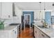 Kitchen area features a gas range, stainless steel appliances, white cabinets, and hardwood floors at 15617 Westfield Blvd, Carmel, IN 46033