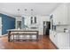 Bright kitchen features an island with seating, white cabinets, stainless steel appliances, and hardwood floors at 15617 Westfield Blvd, Carmel, IN 46033