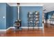 Cozy living room area featuring a wood burning stove, display shelving, hardwood floors, and blue walls at 15617 Westfield Blvd, Carmel, IN 46033