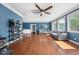 Open living room featuring hardwood floors, a ceiling fan, large windows, and comfortable seating at 15617 Westfield Blvd, Carmel, IN 46033