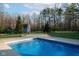 Close up of the in-ground pool with colorful tile accent and surrounding concrete, located in wooded backyard at 15617 Westfield Blvd, Carmel, IN 46033