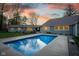 Backyard view of the in-ground pool with concrete surround and a beautiful sunset backdrop on a well-maintained property at 15617 Westfield Blvd, Carmel, IN 46033