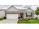 Charming brick home featuring an attached garage, manicured lawn, and a welcoming front entrance at 16044 Loire Valley Dr, Fishers, IN 46037