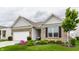 Well-maintained exterior with brick accents, a lush green lawn, and mature tree at 16044 Loire Valley Dr, Fishers, IN 46037