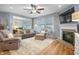 Bright living room with neutral tones, cozy seating, a fireplace, and large windows for natural light at 16044 Loire Valley Dr, Fishers, IN 46037