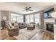 Bright living room featuring comfortable seating, a fireplace, and large windows at 16044 Loire Valley Dr, Fishers, IN 46037