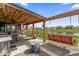 Beautiful covered patio with an outdoor kitchen, a swing, and seating overlooking a scenic water view at 161 Tamarack Larch Blvd, Cicero, IN 46034