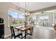 Sun-filled dining area with views of the backyard, modern chandelier and wood floors at 161 Tamarack Larch Blvd, Cicero, IN 46034