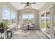 Bright sunroom with large windows overlooking the water and a cozy seating area at 161 Tamarack Larch Blvd, Cicero, IN 46034