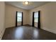 A clean, empty bedroom has updated flooring and two windows dressed with black curtains at 1622 S Randolph St, Indianapolis, IN 46203