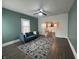 Inviting living room with teal walls, ceiling fan and stylish blue sofa, flows into the adjacent dining area at 1622 S Randolph St, Indianapolis, IN 46203