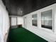 Sunroom with white walls, black wood ceiling, and green carpet providing a cozy indoor space at 1622 S Randolph St, Indianapolis, IN 46203