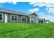 Spacious backyard view of homes with green lawn, covered patio and clear blue sky at 16693 Churning Way, Noblesville, IN 46060