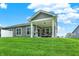 Backyard featuring a covered patio with ample seating and a well-manicured lawn at 16693 Churning Way, Noblesville, IN 46060