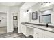 Modern bathroom with dual sinks, gray countertop, white cabinets, and tiled shower with glass door at 16693 Churning Way, Noblesville, IN 46060