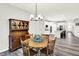 Light-filled dining area with table set and chairs open to the modern kitchen at 16693 Churning Way, Noblesville, IN 46060