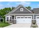 Charming home showcasing a two-car garage, stone accents, a gray facade, and a well-manicured lawn at 16693 Churning Way, Noblesville, IN 46060