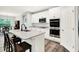 Open concept kitchen showcasing stainless steel appliances, a functional island bar, wood floors, and stylish pendant lighting at 16693 Churning Way, Noblesville, IN 46060