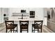 Modern kitchen featuring stainless steel appliances, a kitchen island with seating, white cabinetry, and stylish gray countertops at 16693 Churning Way, Noblesville, IN 46060
